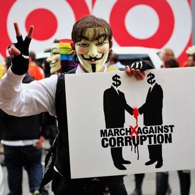 Ein Mann mit Guy Fawkes-Maske protestiert bei einer Kundgebung.